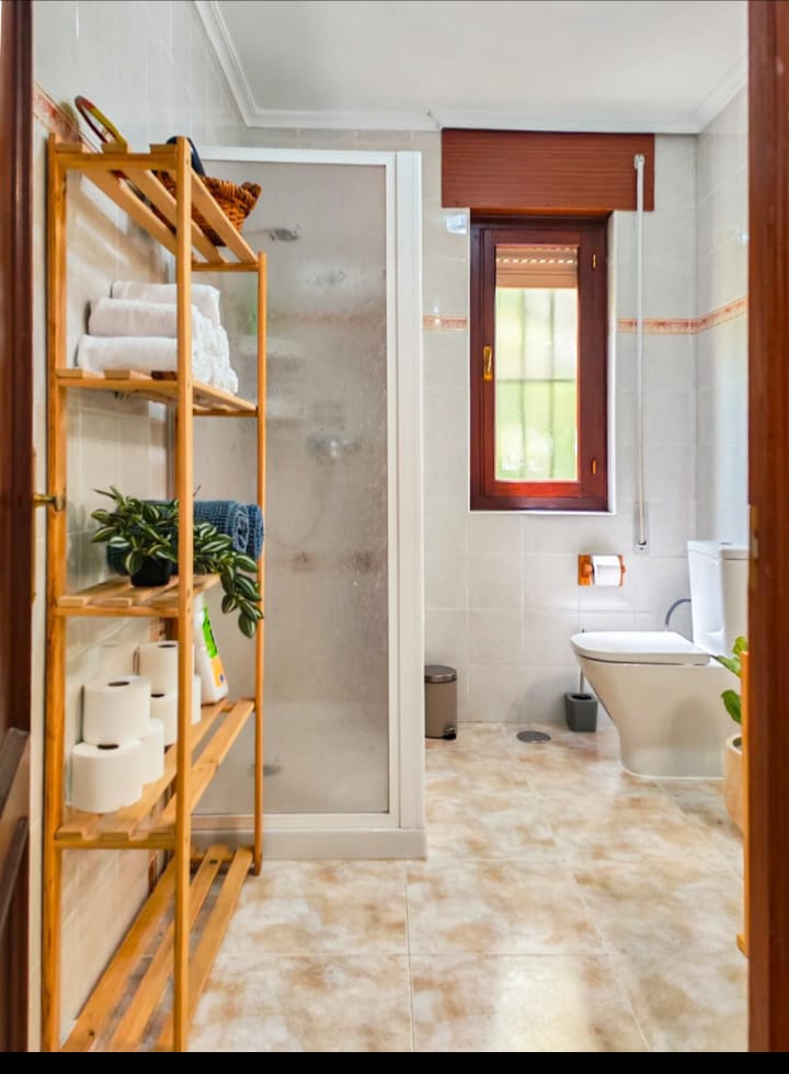La Casa del Valle - Baño con estantería de madera natural