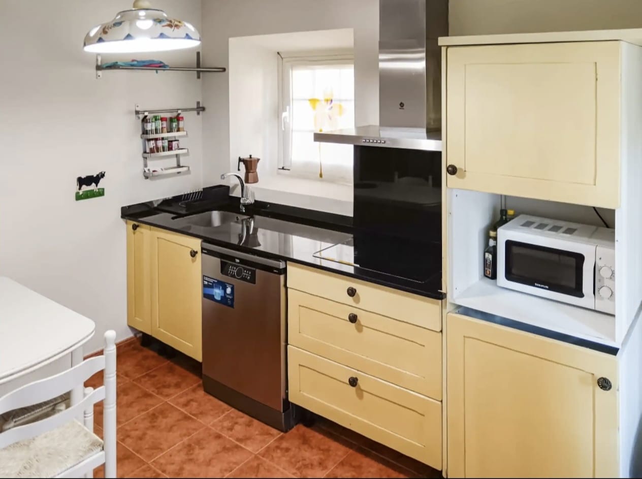 Cocina rústica con encimera de piedra en alojamiento rural
